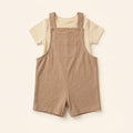 Oat-beige cotton dungaree over a white tee, laid flat